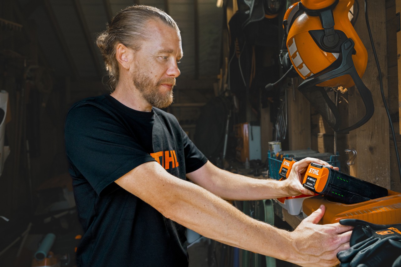 Andrew Wain legt einen Akku in ein STIHL Schnellladegerät