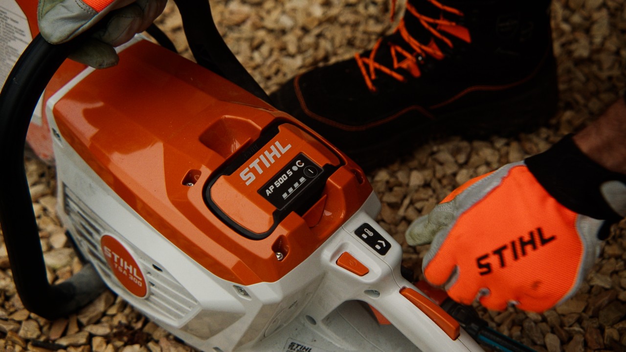 Nahaufnahme vom STIHL TSA 300 Akku-Trennschleifer mit AP 500 S Akku, ein robustes Profi-Gerät mit ergonomischem Griff und Bedienelementen für präzise Schneidarbeiten im Aussenbereich.