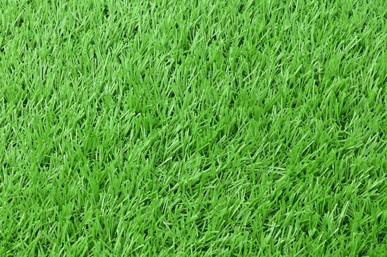 Artificial grass flooring, building decoration materials, Indoor stadium or football fields, playgrounds, landscaping. Example of artificial grass in a white background.