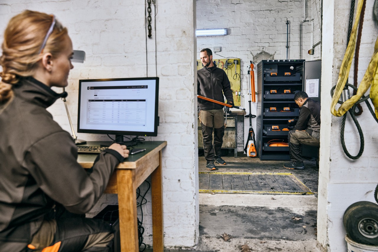 Jardiniers paysagistes professionnels dans leur atelier, une femme est assise devant le portail STIHL connecté.