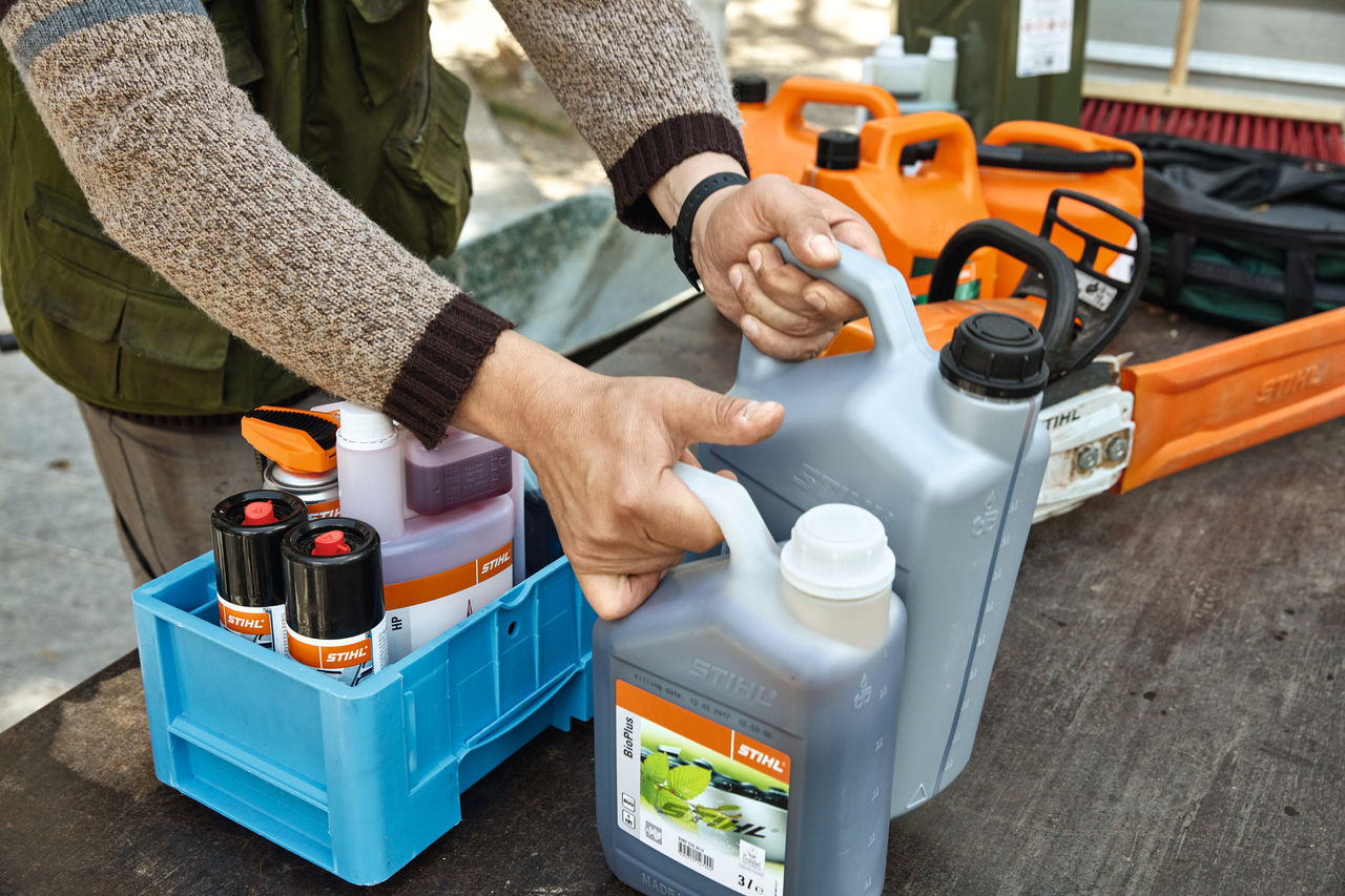 Personne rangeant des consommables STIHL dans des caisses de transport 