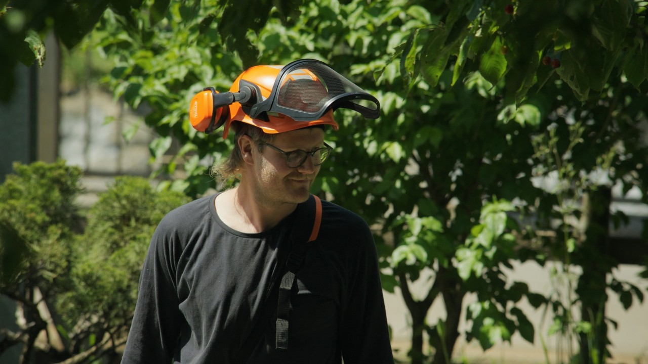 Scena della campagna STIHL Real People, Achille durante lavori di giardinaggio con attrezzatura professionale, autentica quotidianità lavorativa all’aperto